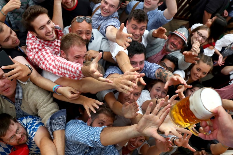 People reach out for a glass of beer (Matthias Schrader/AP)