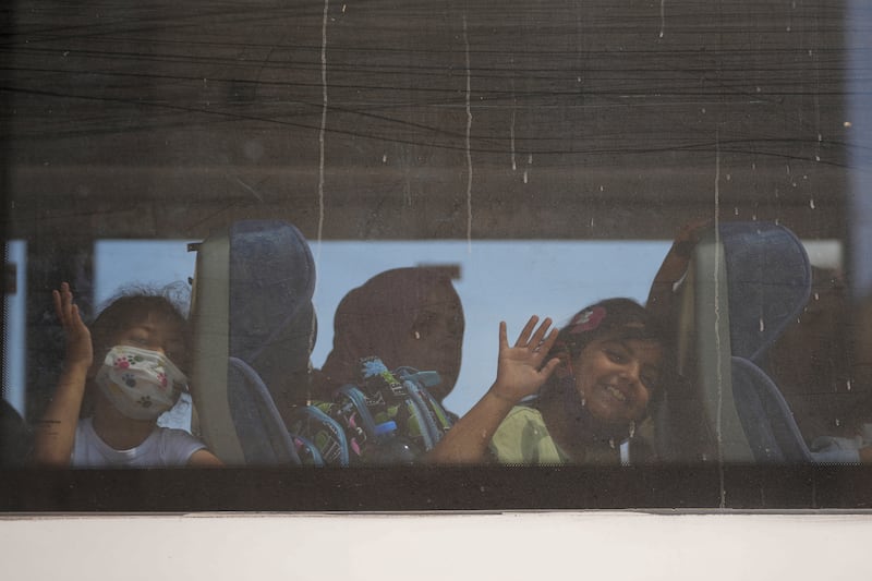 Children wave goodbye to their relatives as they leave the Gaza Strip (Abdel Kareem Hana/AP)