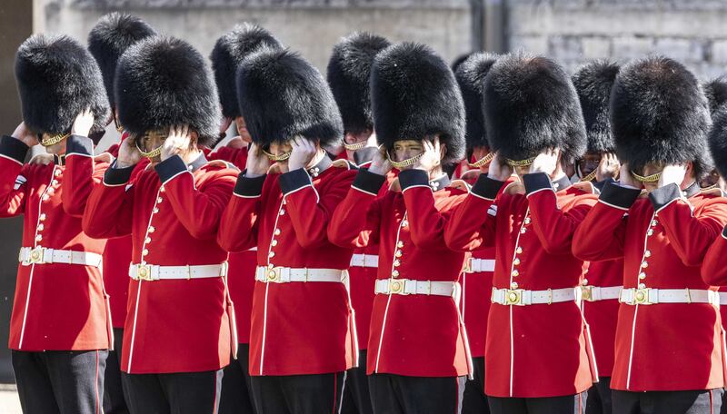 Guardsmen of the 1st battalion Irish guards remove their ceremonial bearskin hats during a parade at Windsor Castle