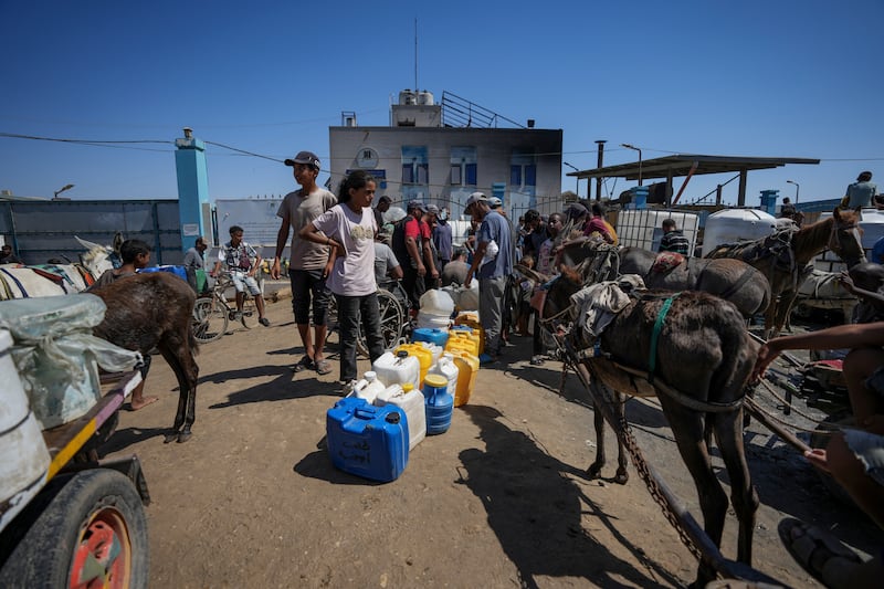 Displaced Palestinians line up to collect water in Deir al Balah, central Gaza Strip (Abdel Kareem Hana/AP)