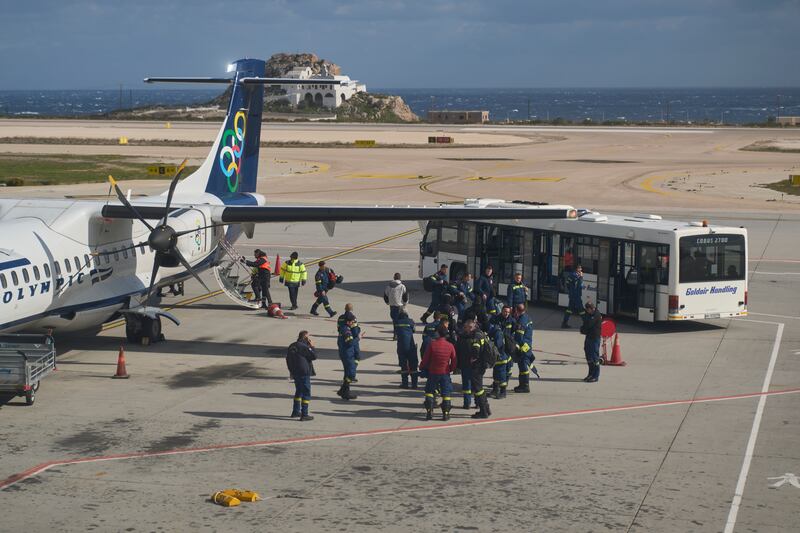 Fire service rescuers arrived at the airport of Santorini as emergency efforts were stepped up (Petros Giannakouris/AP)