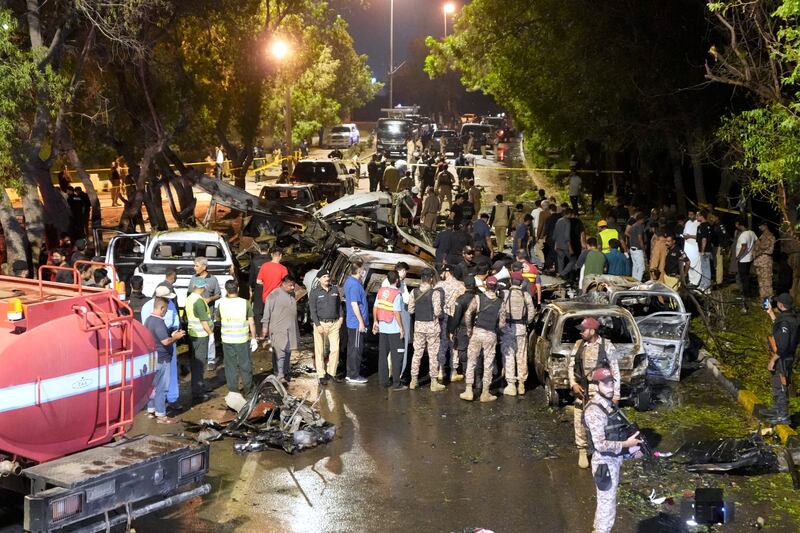 Security officials examine the site of the explosion (Fareed Khan/AP)