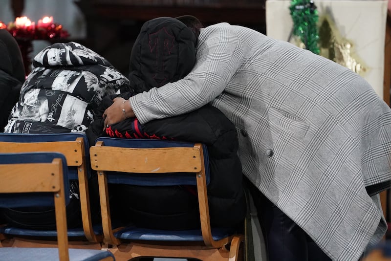 People hug during a vigil at St Mary Magdalene church