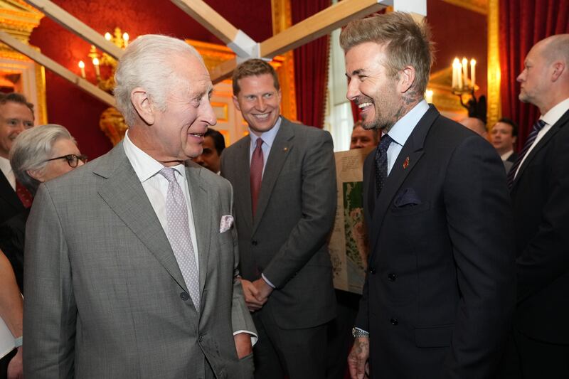 The King smiles as he speaks to David Beckham