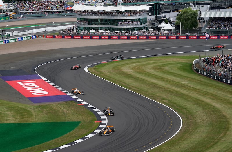 McLaren’s Lando Norris leads Red Bull’s Max Verstappen through Brooklands during the British Grand Prix