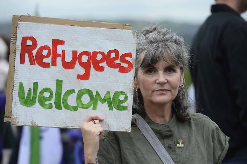 A woman holds up a sign during a protest by unions at Stormont