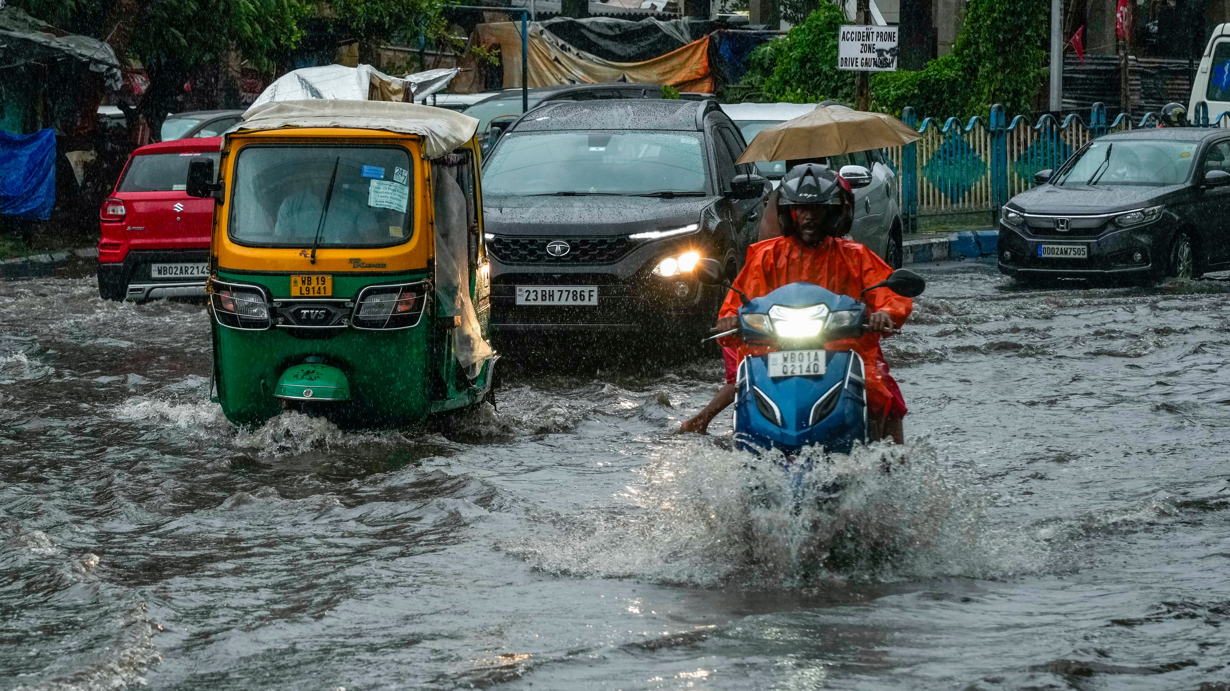 Vehicles move through a waterlogged street in Kolkata, India (AP Photo/Bikas Das)