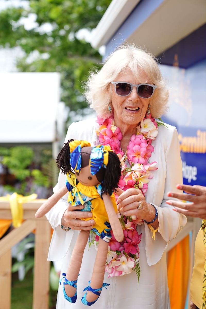 Camilla holds a gift presented to her during a visit to the Samoa Victim Support Group