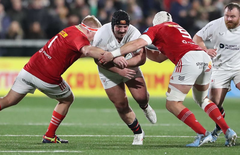 Ulster Rugby's Tom O'Toole tackled by Munster's John Ryan and Fineen Wycherley during their United Rugby Championship match at Kingspan Stadium