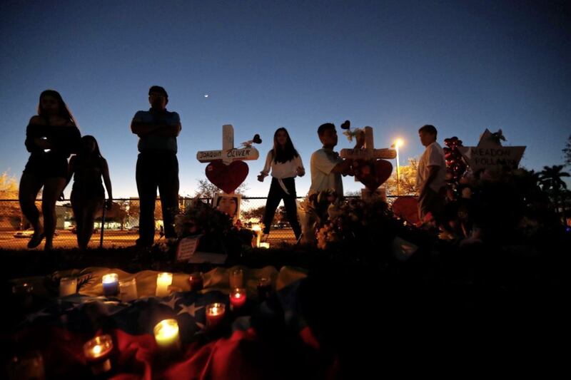 People visit a makeshift memorial outside Marjory Stoneman Douglas High School, where 17 students and faculty were shot dead in Wednesday&#39;s mass shooting in Florida PICTURE: Gerald Herbert 