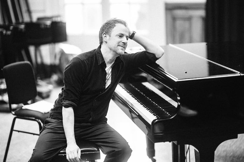 Armagh-born composer Gareth Williams sitting at a piano