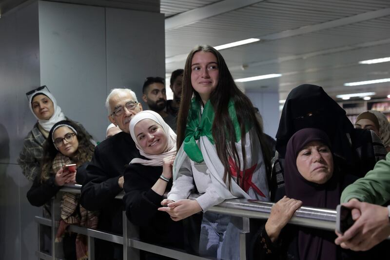 People wait to receive their relatives at the arrival terminal (Omar Sanadiki/AP)