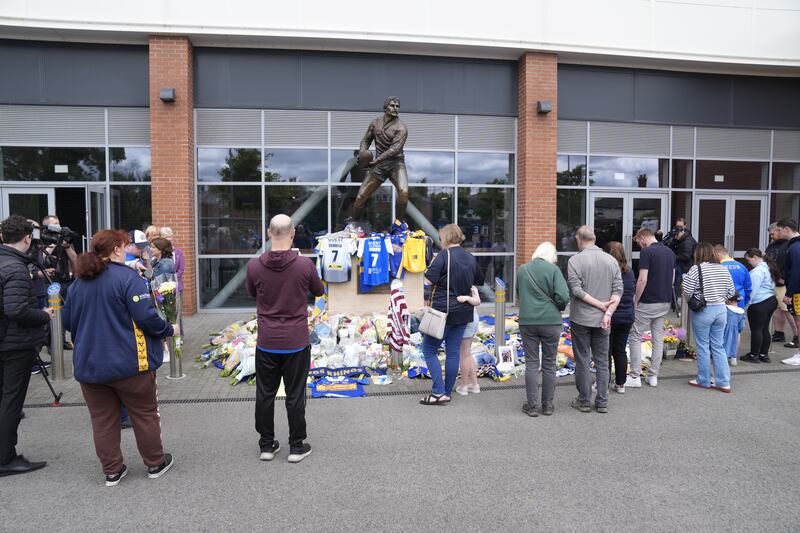 Members of the public pay tribute and view flowers and messages left at Headingley Stadium in Leeds, following the death of former Leeds Rhino player Rob Burrow who had MND