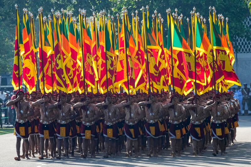 Sri Lankans dressed as ancient soldiers carry their national flags during the country’s Independence Day (Eranga Jayawardena/AP)