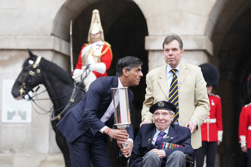 Prime Minister Rishi Sunak hands the Commonwealth War Graves Commission’s (CWGC) Torch of Commemoration to navy seaman D-Day veteran Peter Kent, 99, at Horse Guards, Whitehall