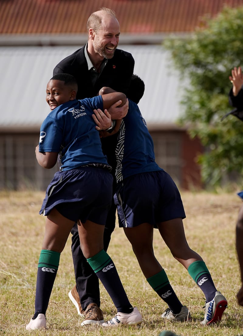 The Prince of Wales takes part in a rugby coaching session with local schoolchildren