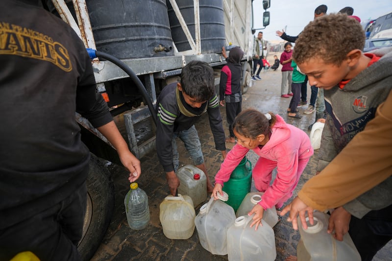 Children collect water from a truck at a tent camp for displaced Palestinians in Deir al-Balah, Gaza Strip (Abdel Kareem Hana/AP)