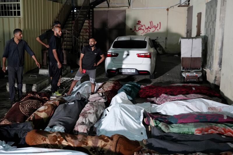 Palestinians mourn in front of the morgue of Al-Aqsa Martyrs Hospital in Deir al-Balah (Abdel Kareem Hana/AP)