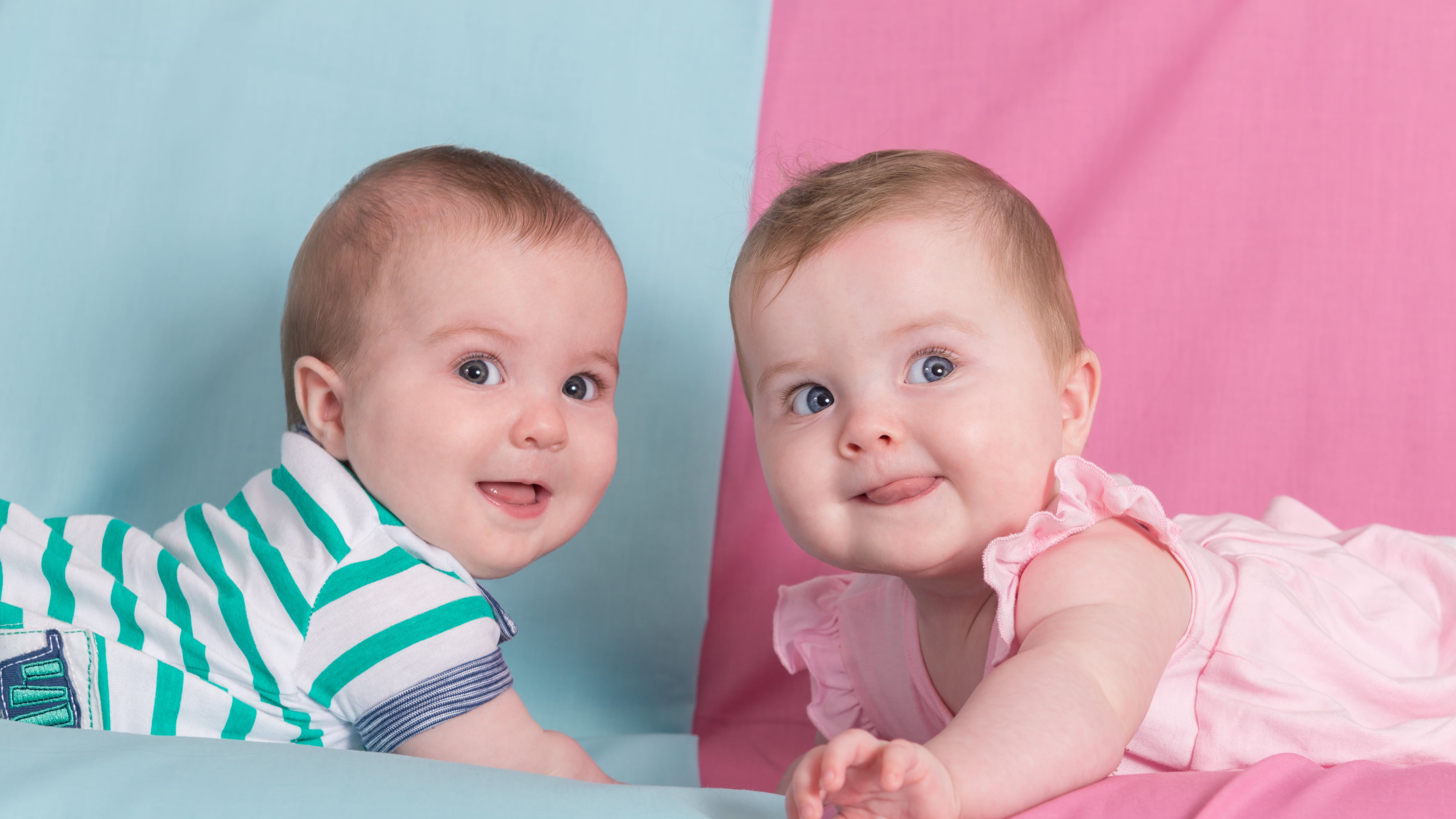 brother and sister - twins babies girl and boy on pink and blue background
