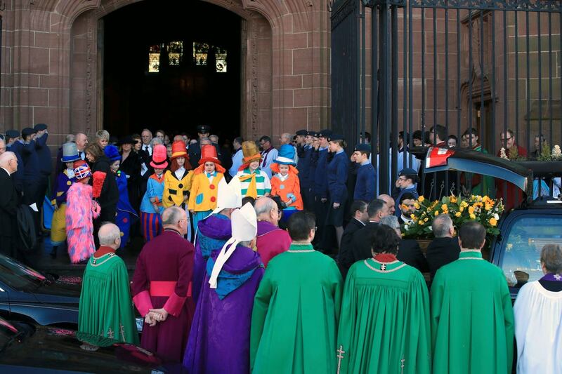 Children dressed as Diddymen watch the funeral cortege leave (Peter Byrne/PA)