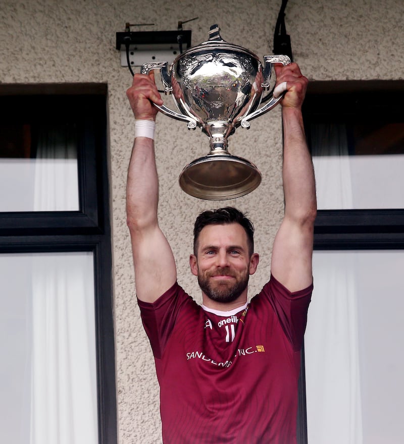 Cushendall captain Neil McManus raises the Volunteer Cup. Picture: Seamus Loughran