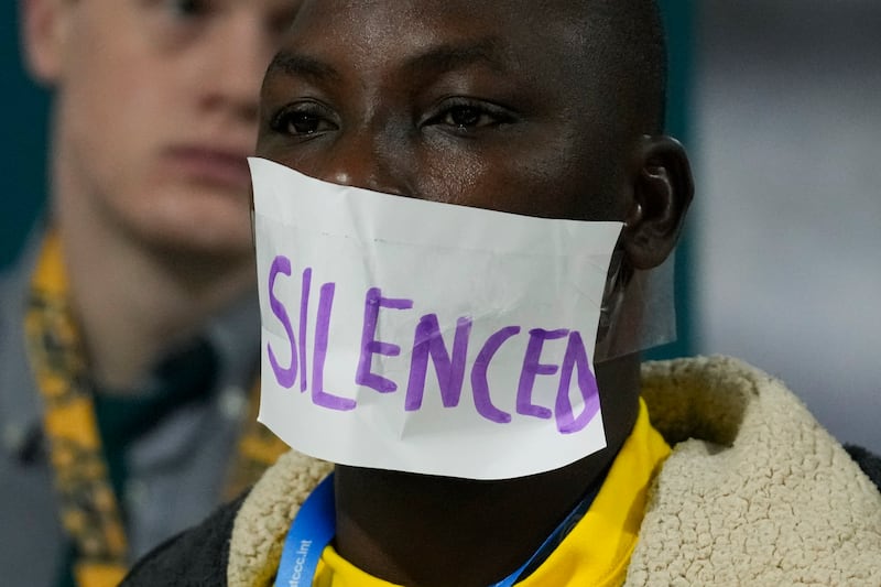 An activist with the word ‘silenced’ over his mouth at the climate summit (Rafiq Maqbool/AP)