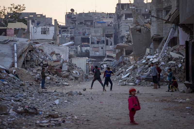 Palestinian children play next to buildings destroyed by Israeli army strikes in Khan Younis (Abdel Kareem Hana/AP)