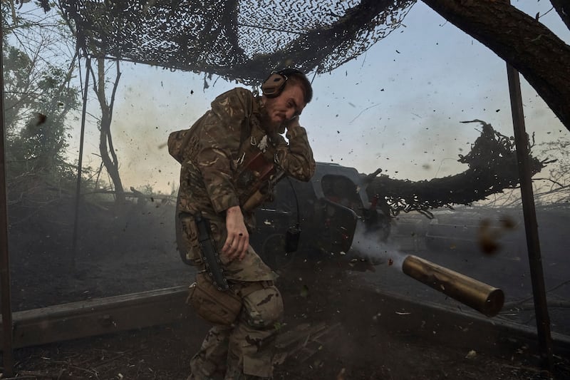 A Ukrainian serviceman fires a D-30 cannon towards Russian positions at the front line near Bakhmut in the Donetsk region (Libkos/AP)