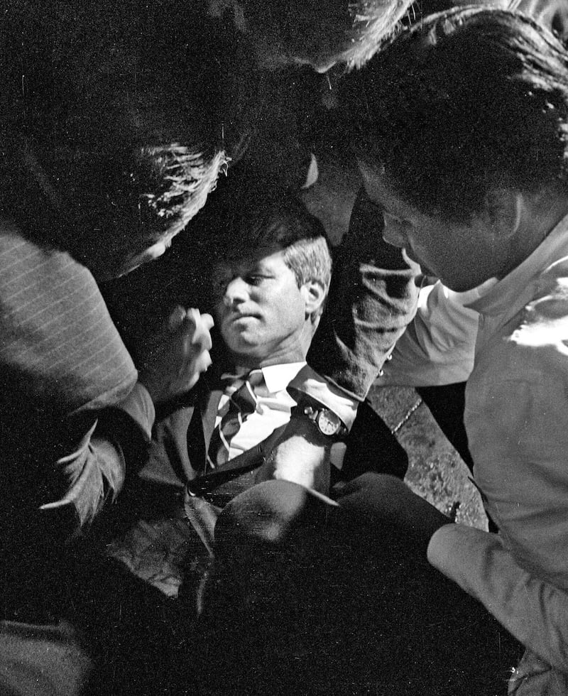 Hotel busboy Juan Romero, right, comes to the aid of Senator Robert F Kennedy as he lies on the floor of the Ambassador Hotel in Los Angeles moments after being shot (Richard Drew/Pasadena Star News/AP)