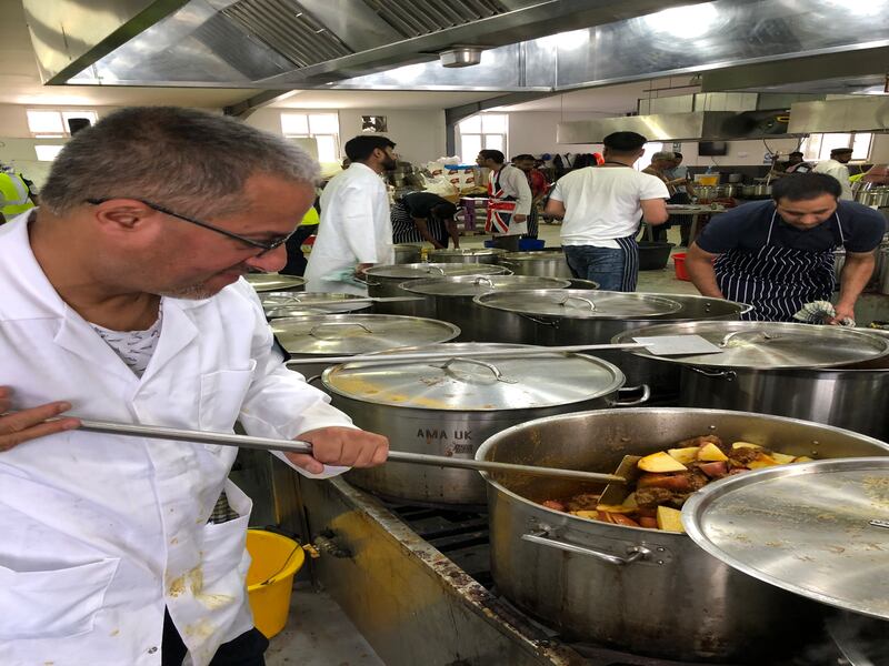 Javed Uddin stirring a pot with meat and potatoes 