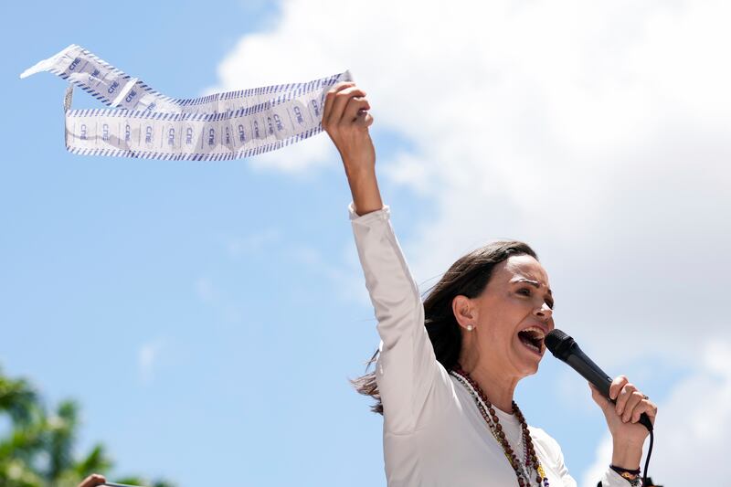 Opposition leader Maria Corina Machado displays vote tally sheets during the protest (Ariana Cubillos/AP)