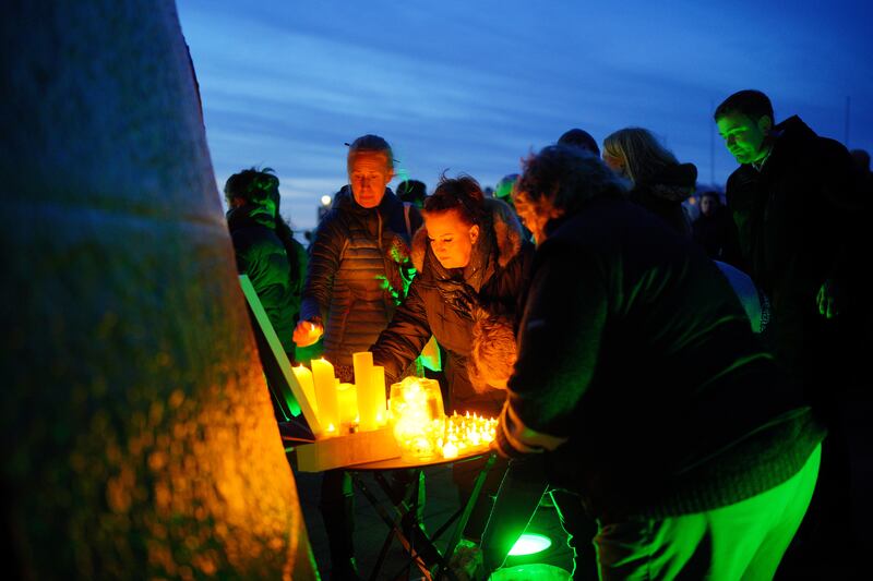 People light candles during Monday’s vigil