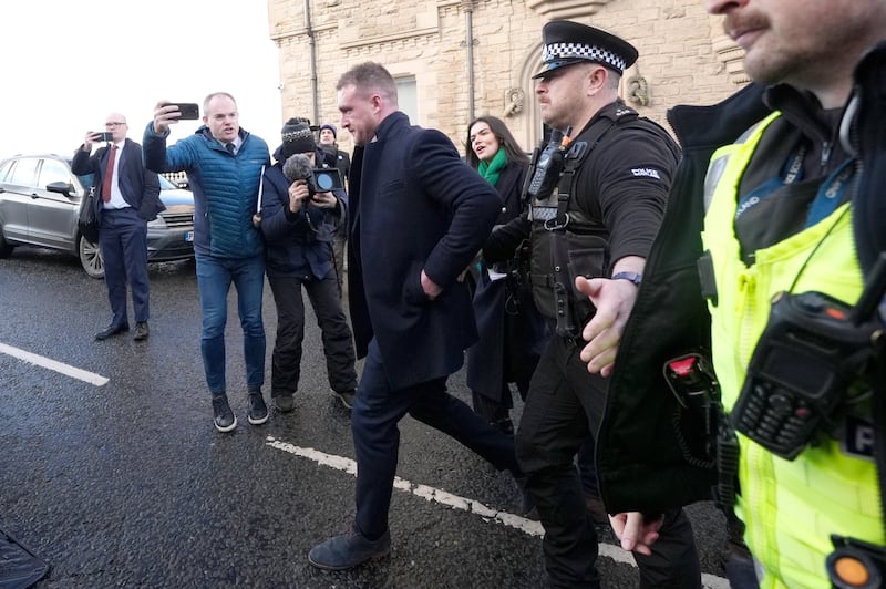 Stuart Hogg, centre, was escorted to a waiting car by police outside the court