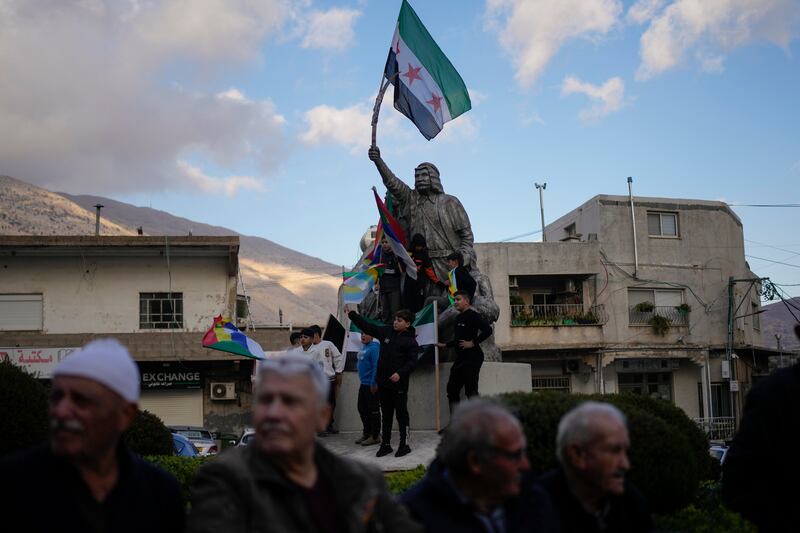 People attend a rally celebrating the fall of Syrian President Bashar Assad’s government. It comes as the prime minister said that Cabinet ministers were back at work (AP Photo/Matias Delacroix)