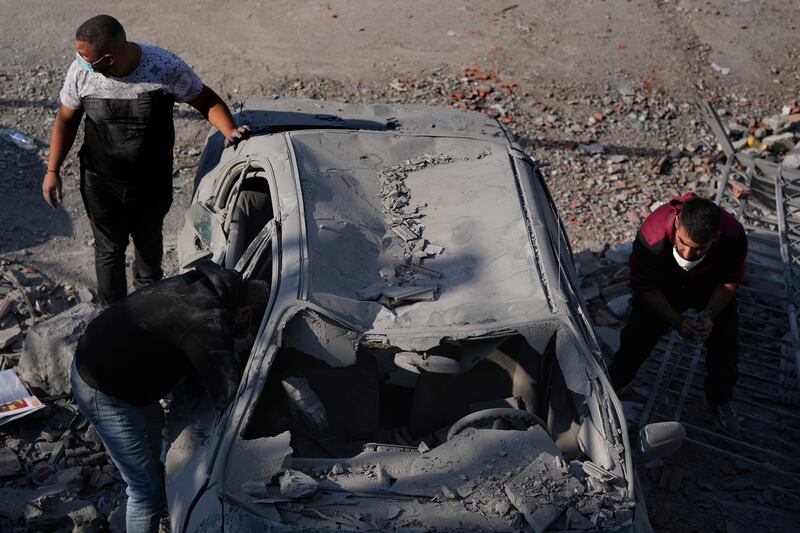 People check a damaged car at the site of the air strike on Aalmat, Lebanon (Hassan Ammar/AP)