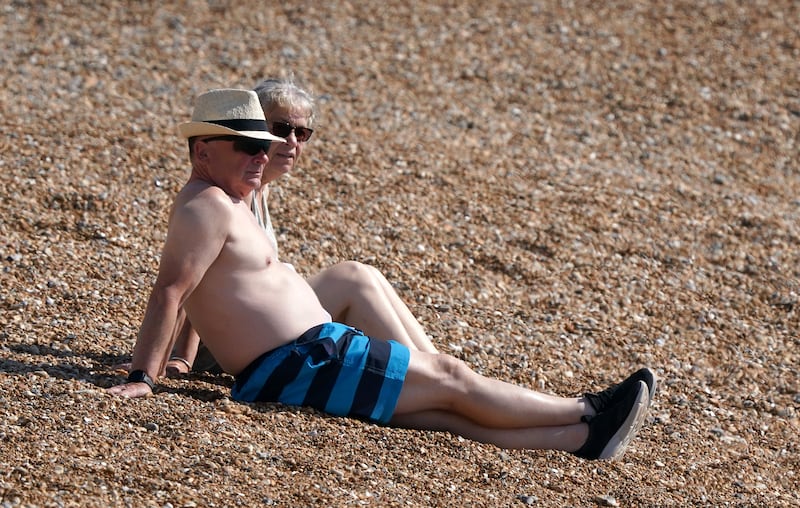 A couple enjoy the warm weather on the beach in Dover