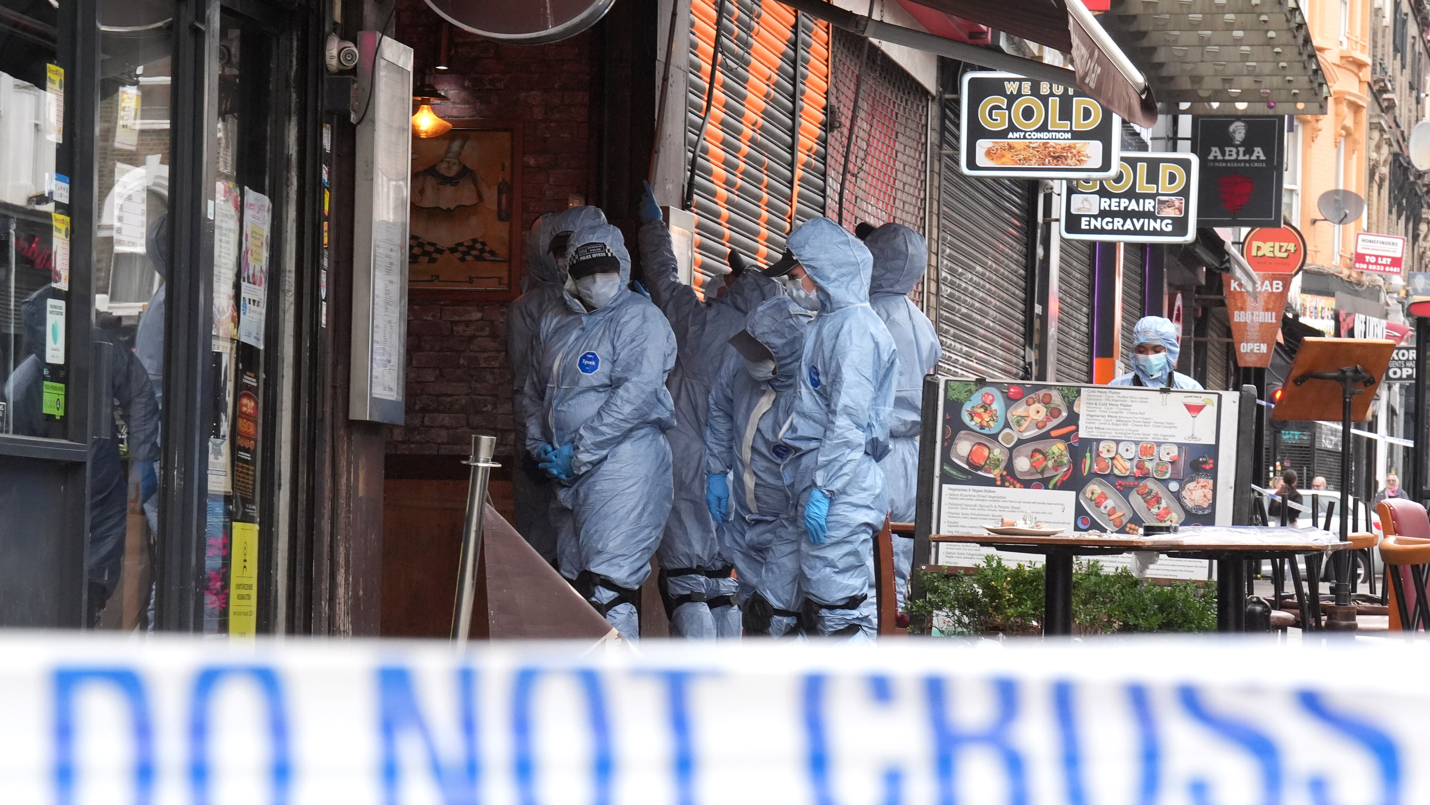 Police forensic officers at the scene of the shooting at Kingsland High Street in Hackney, east London