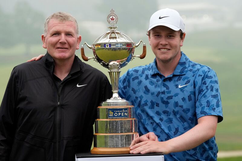 Scotland’s Robert MacIntyre (right) and his father and caddie Dougie pose for photos with the RBC Canadian Open trophy (Frank Gunn/The Canadian Press via AP)