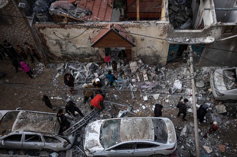 Palestinians look at the destruction after an Israeli airstrike in Rafah, in the Gaza Strip, on Friday (Fatima Shbair/AP)