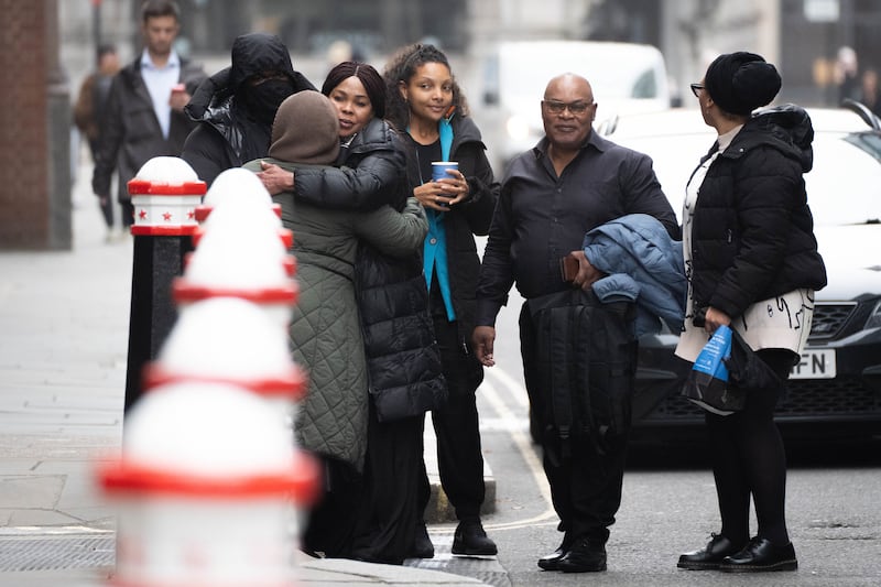 Helen Lumuanganu the mother of Chris Kaba hugs friends alongside Prosper Kaba, the father of Chris Kaba outside the Old Bailey