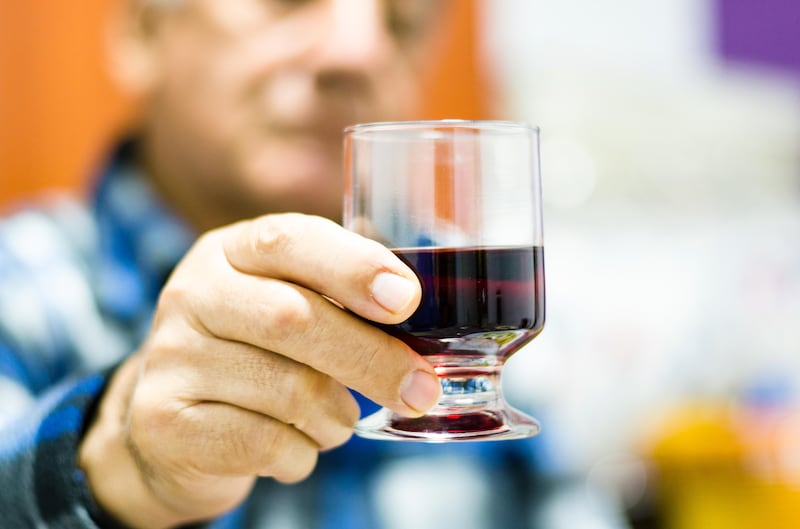 Middle aged man holding a glass of red wine