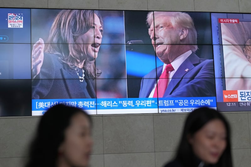 A screens shows images Kamala Harris and Donald Trump during a news programme in South Korea (Lee Jin-man/AP)