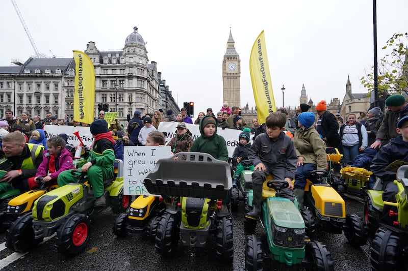 Children on toy tractors during a farmers protest in central London