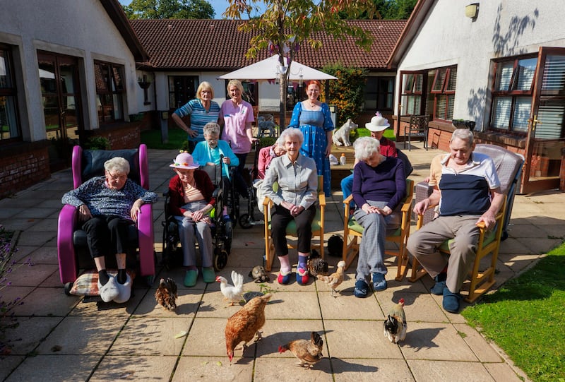 Seapatrick Care Home residents with Catherine Hoy (back row to the right in blue dress) and Sharon Bell (back row centre in pink tunic) Activities Coordinator during a pet therapy session at the Banbridge Care Home. Picture date: Thursday September 19, 2024. PA Photo. See PA story ULSTER Animals. Photo credit should read: Liam McBurney/PA Wire