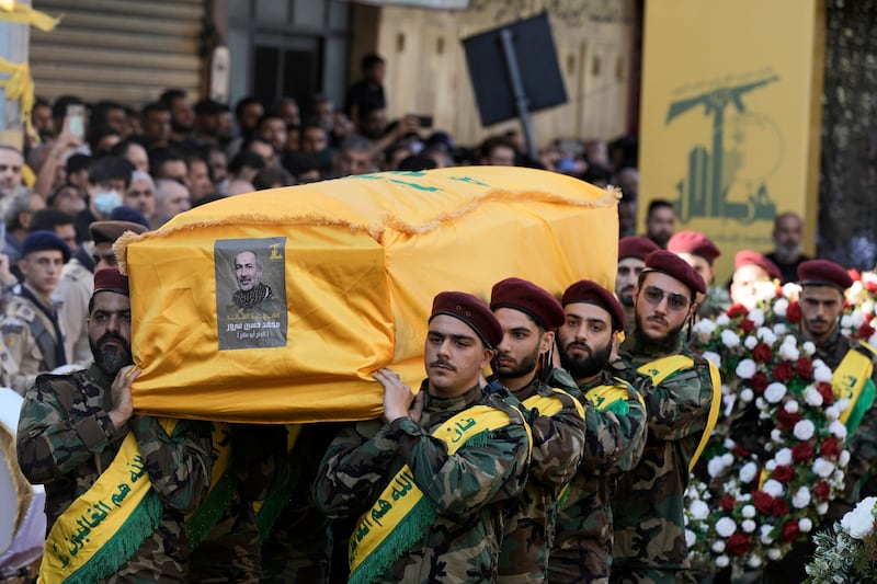 Hezbollah members carry the coffin of drone commander Mohammed Hussein Surour (Bilal Hussein/AP)