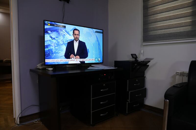 An Iranian state TV newsreader reads news on an incident of a helicopter carrying Iranian President Ebrahim Raisi in north-western Iran (Vahid Salemi/AP)