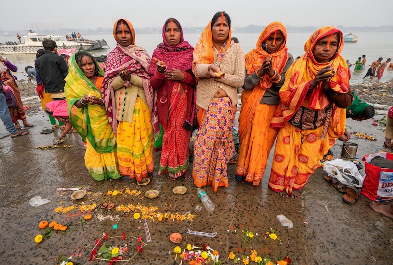 Hindu pilgrims perform rituals after taking a holy dip in the Hooghly River in Kolkata, India (Bikas Das?AP)