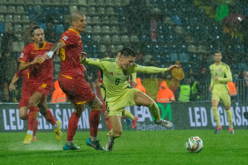 Harry Wilson (right) holds off Montenegro’s Slobodan Rubezic during their Nations League victory (Risto Bozovic/AP)