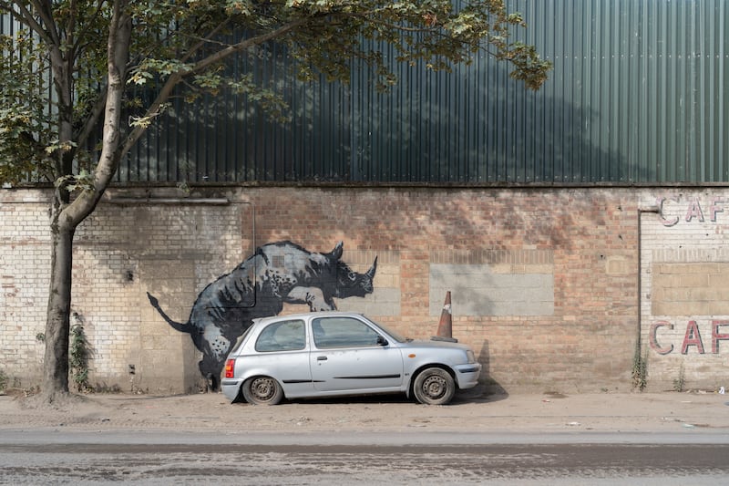 Banksy’s latest artwork depicts a rhinoceros climbing on top of a car