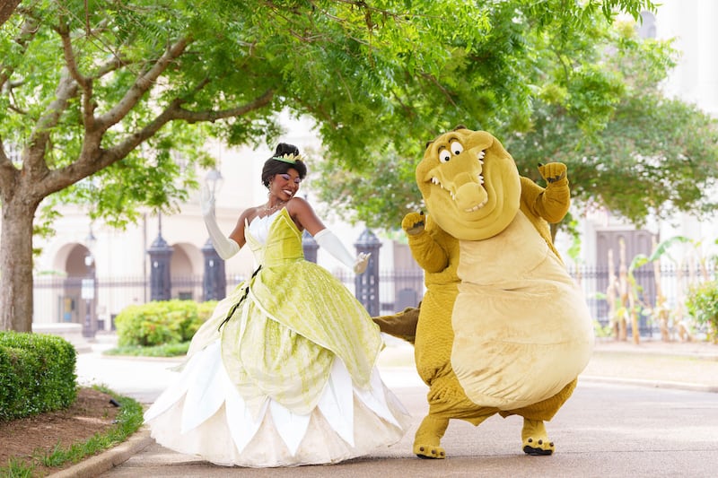 Princess Tiana and Louis the alligator from The Princess And The Frog and the Tiana’s Bayou Adventure attraction at Walt Disney World in Florida dance together